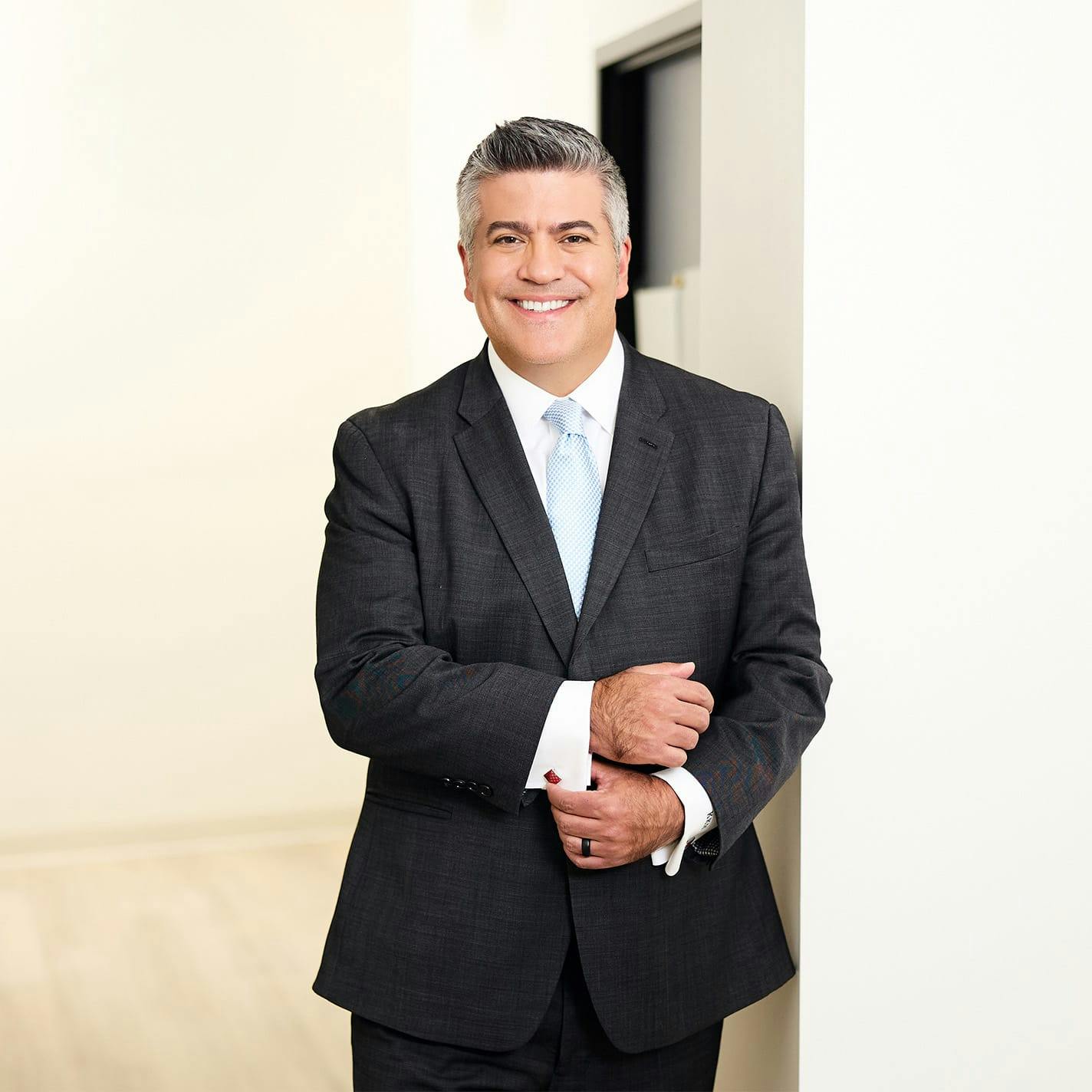 Dr. Higdon in suit holding his cuff