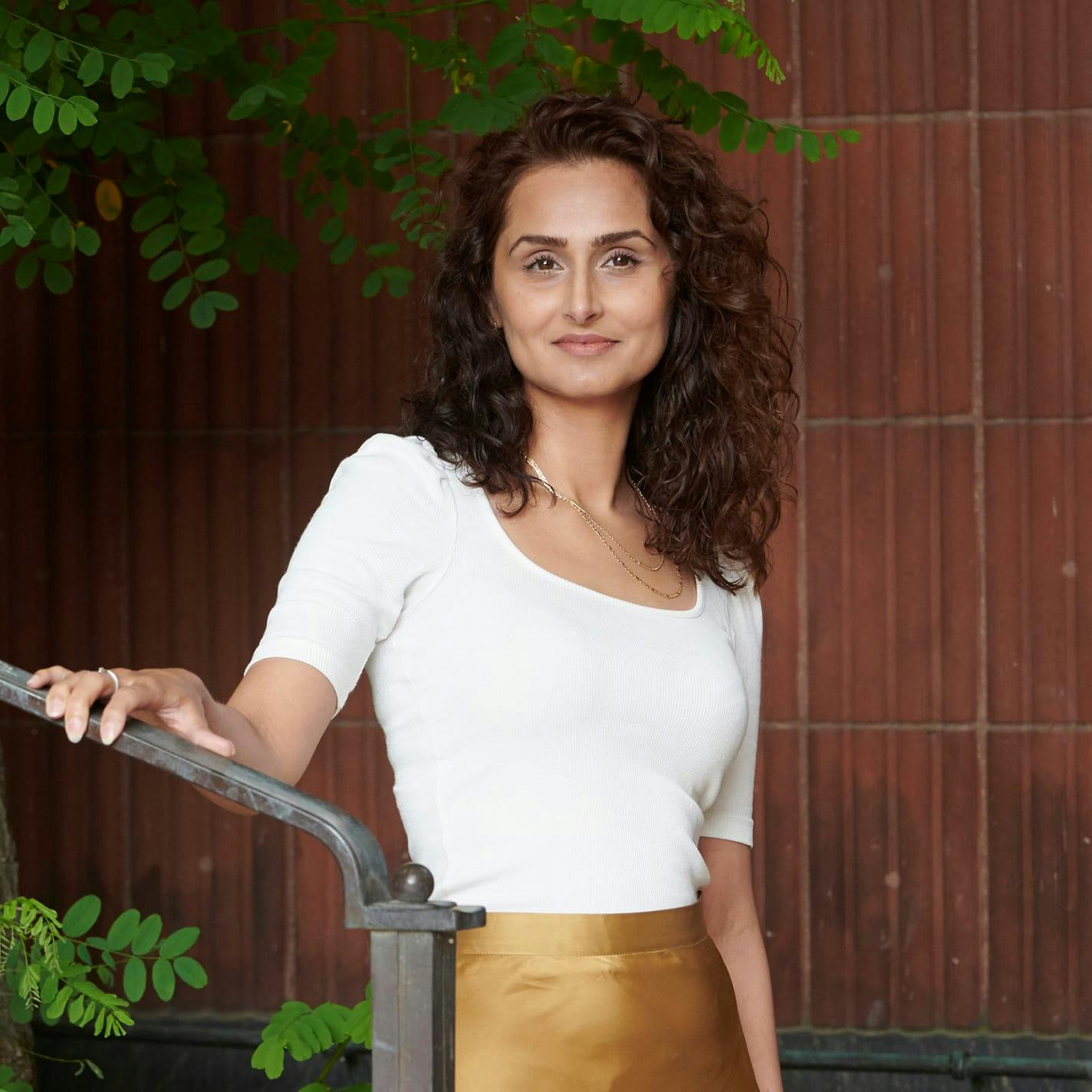 woman with curly brown hair holding onto railing