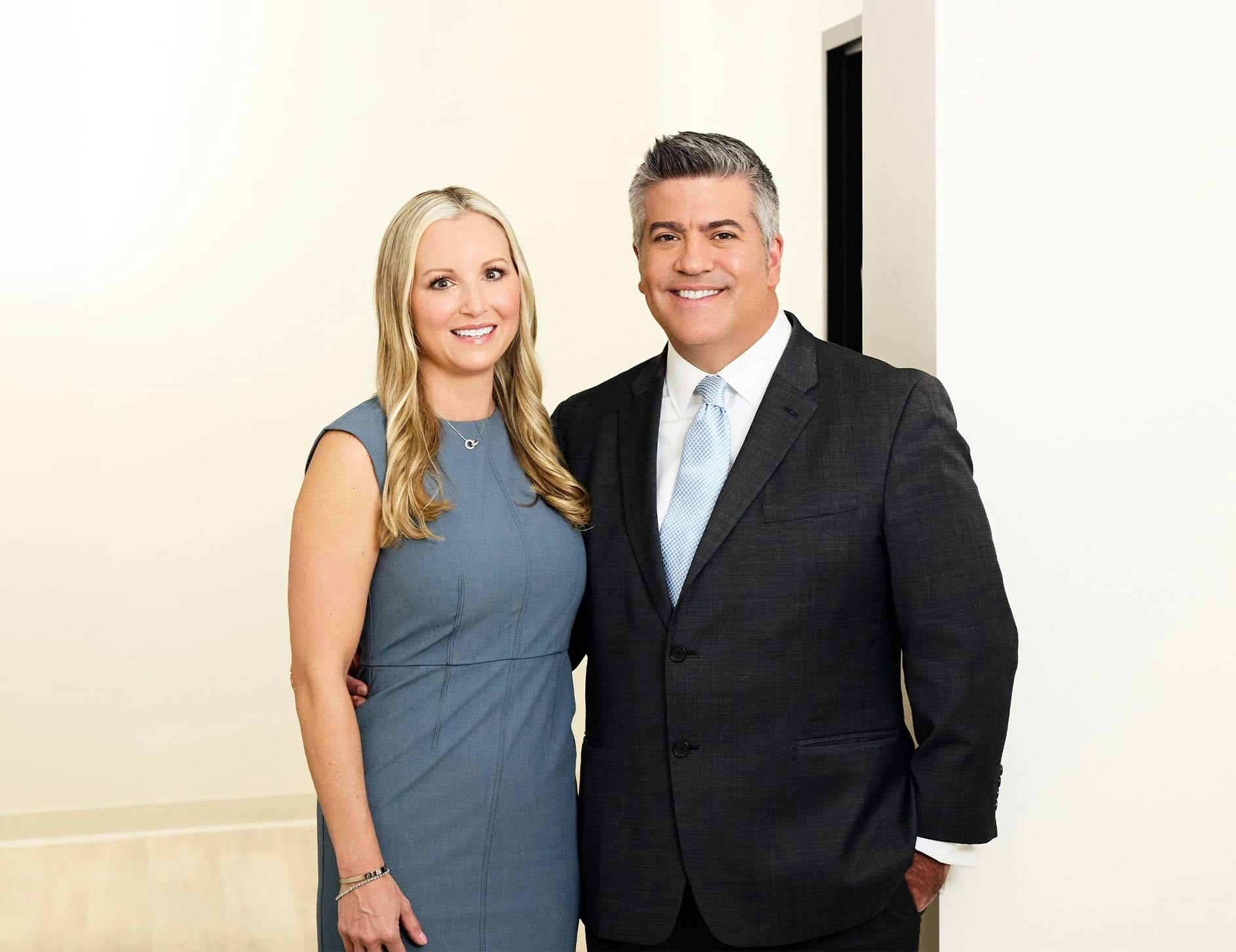 Dr. Higdon with woman in blue dress smiling together looking forward