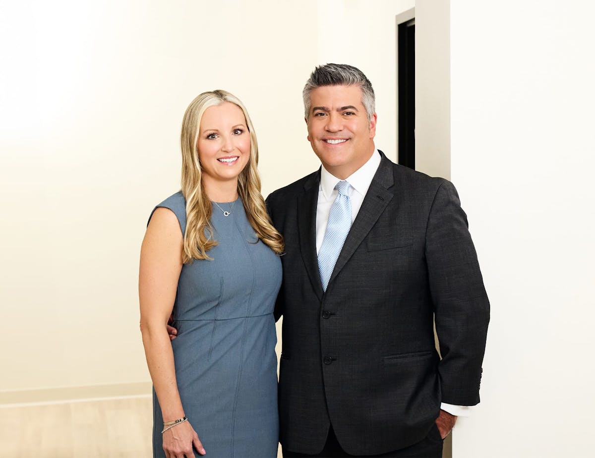 Dr. Higdon with woman in blue dress smiling together looking forward