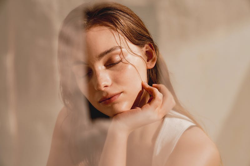 Young woman with beautiful skin has sunlight hitting her face in studio shoot