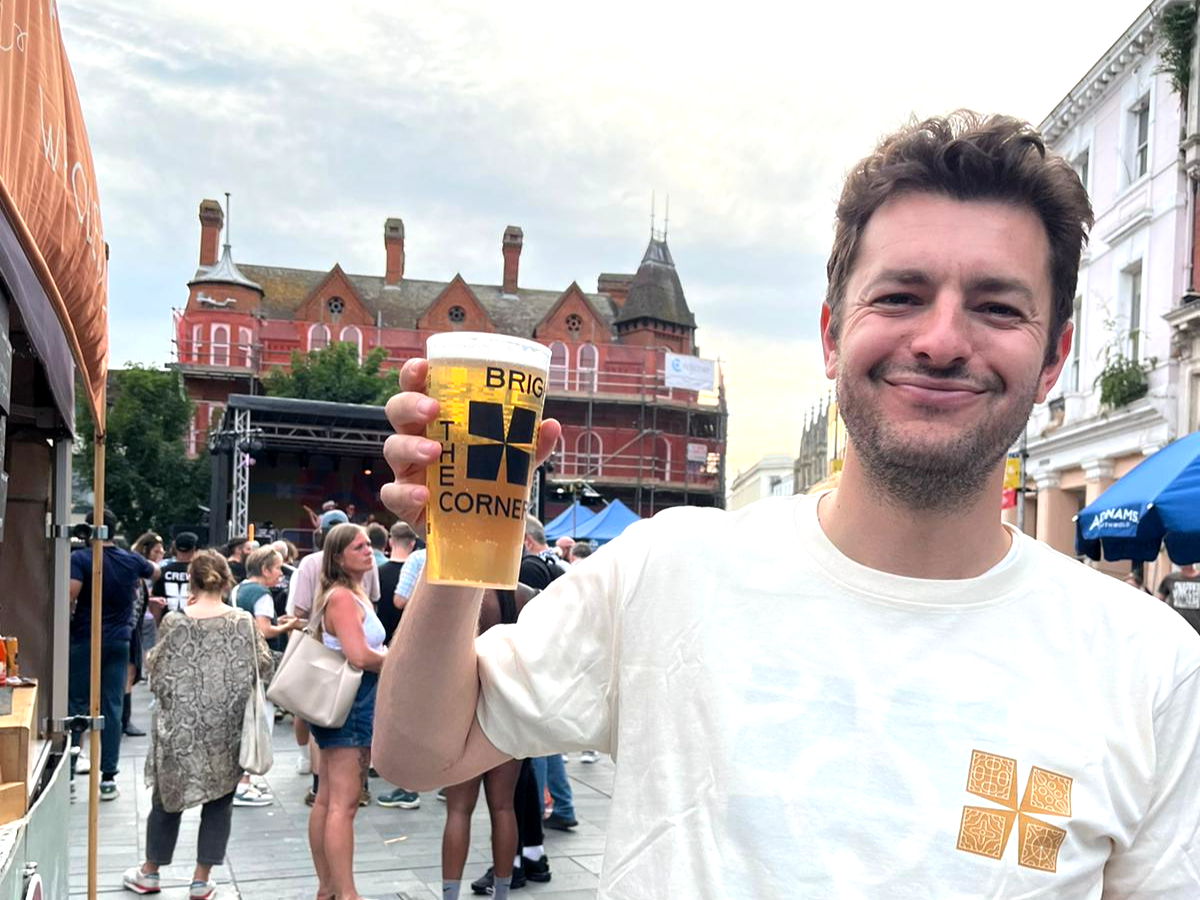 Ipswich MP Jack Abbott nursing a beer at Brighten the Corners 2025