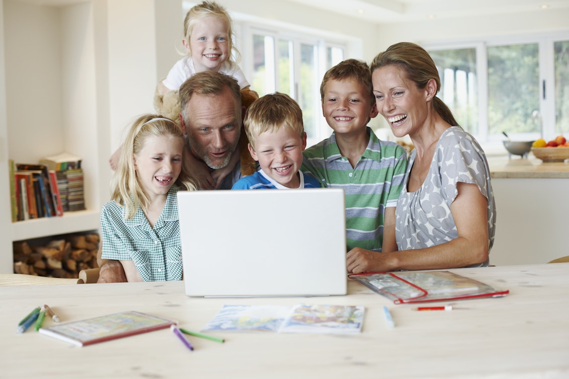 Familie sitzt gemeinsam vor einem Laptop