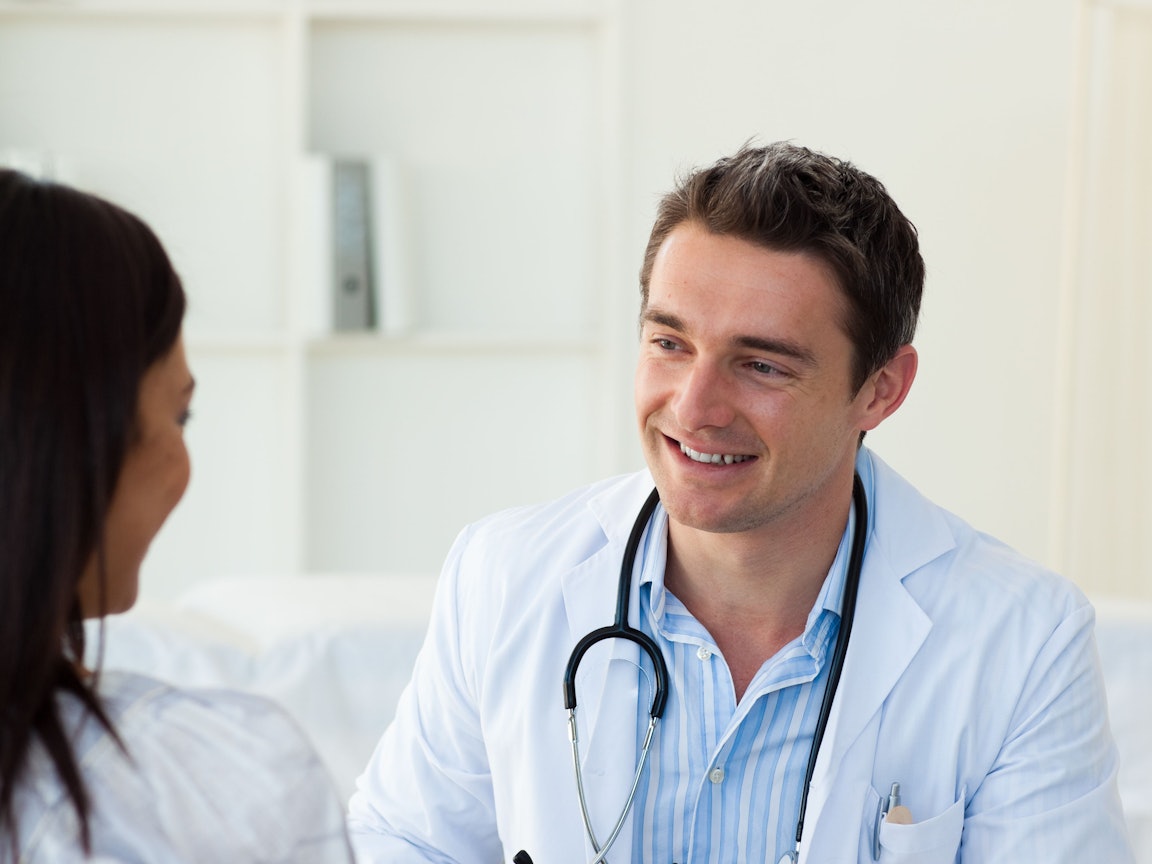 Arzt händigt seiner Patientin ein Rezept aus Arzt händigt seiner Patientin ein Rezept aus