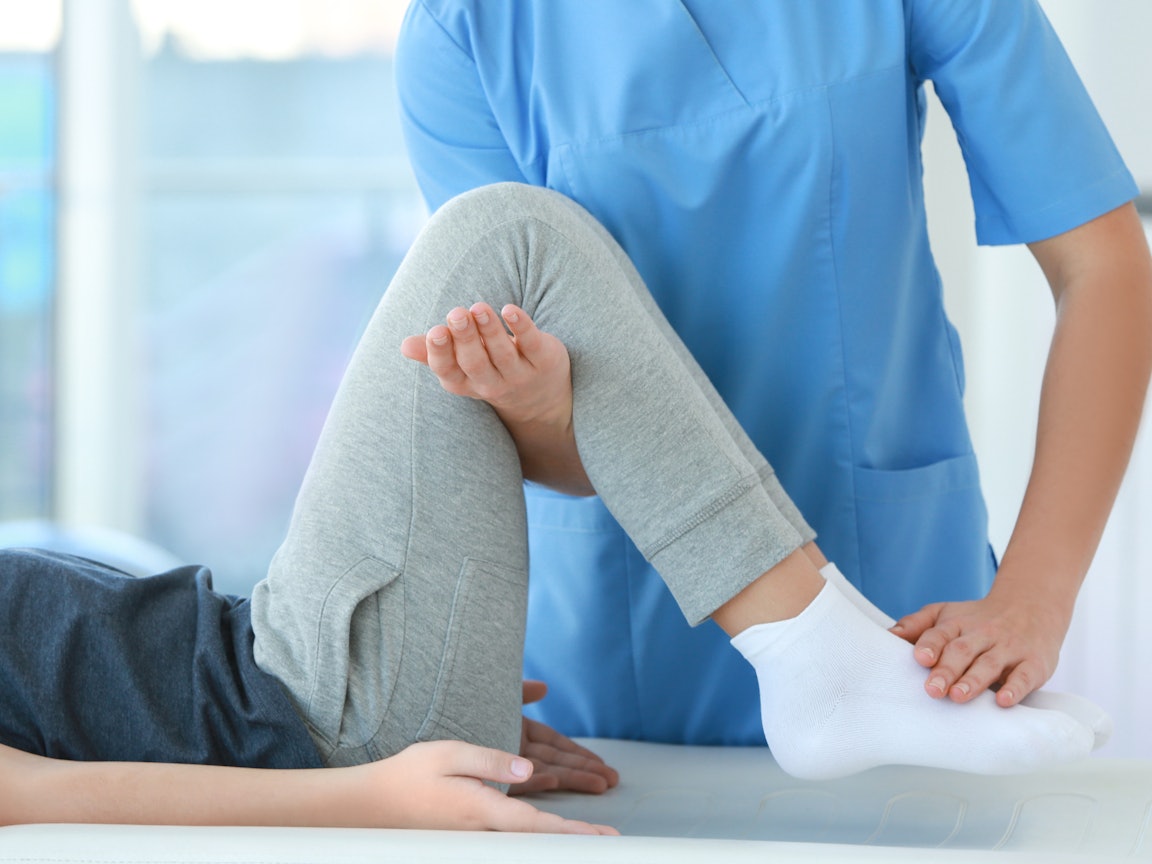 Physiotherapeutin behandelt eine Frau Physiotherapeutin behandelt eine Frau