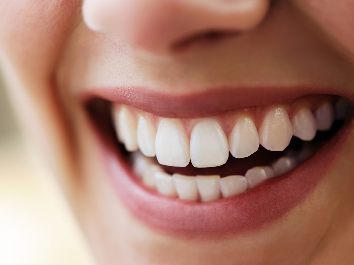 Frau lächelt mit strahlend weißen Zähnen Frau lächelt mit strahlend weißen Zähnen