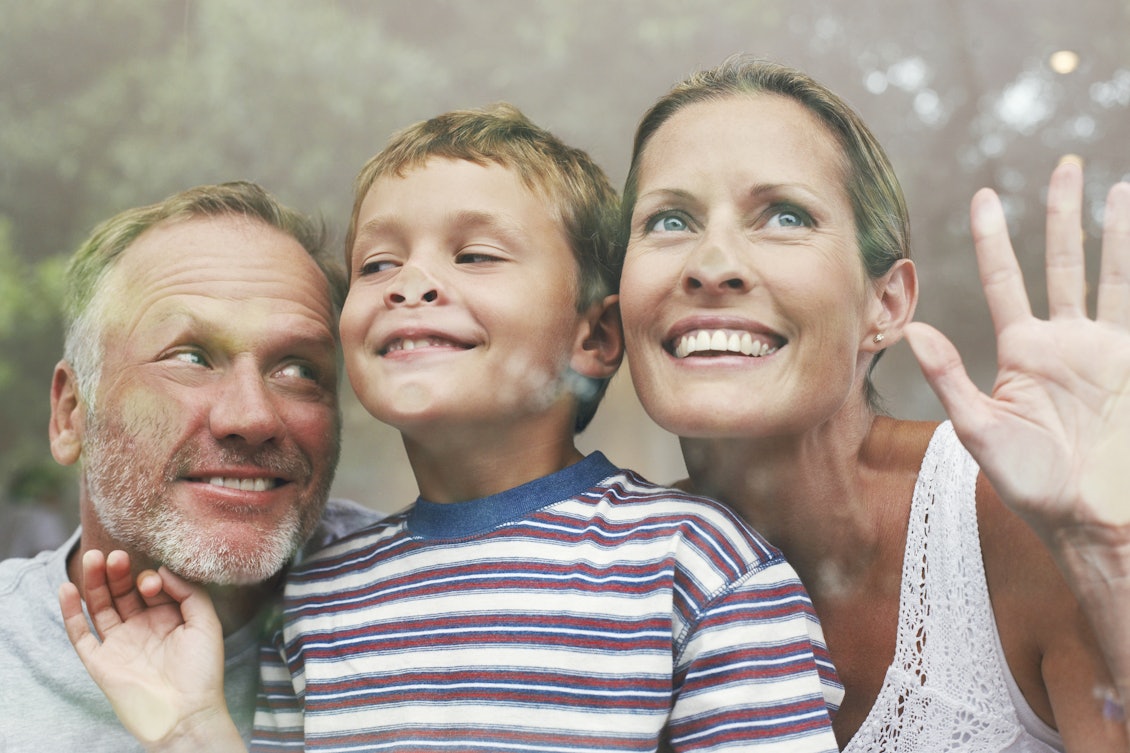 Eltern mit kleinem Sohn stehen am Fenster Eltern mit kleinem Sohn stehen am Fenster