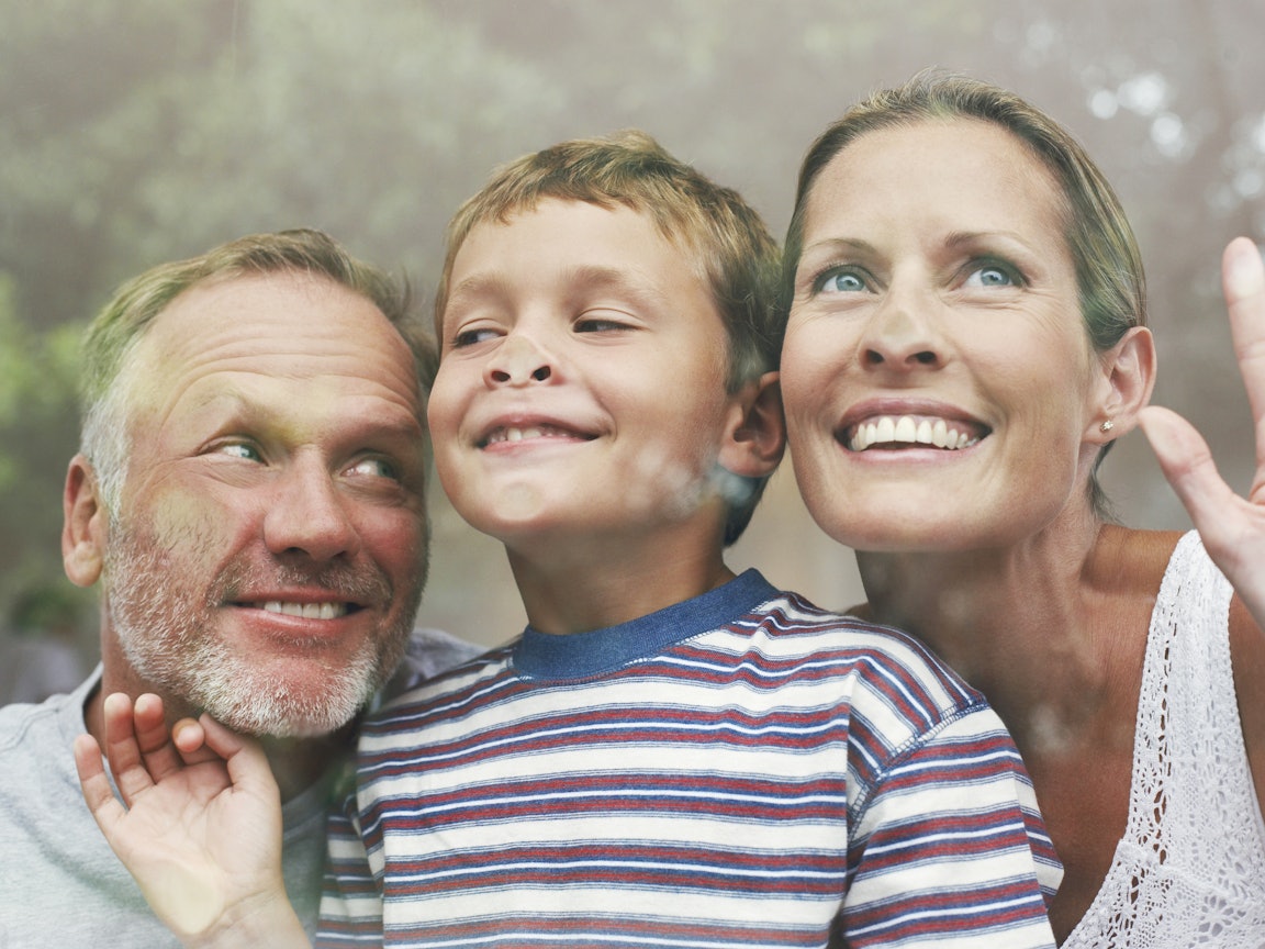 Eltern mit kleinem Sohn stehen am Fenster Eltern mit kleinem Sohn stehen am Fenster