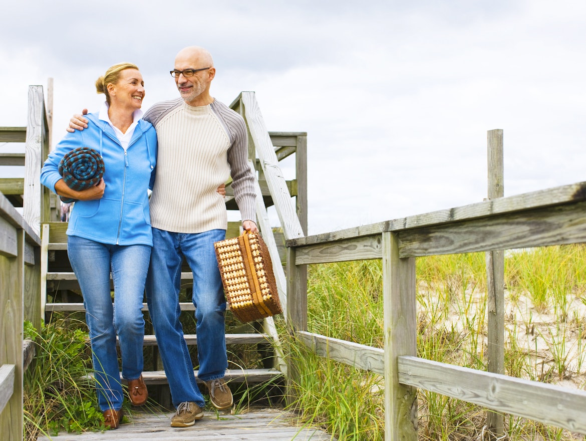 Paar geht zum Picknick an den Strand