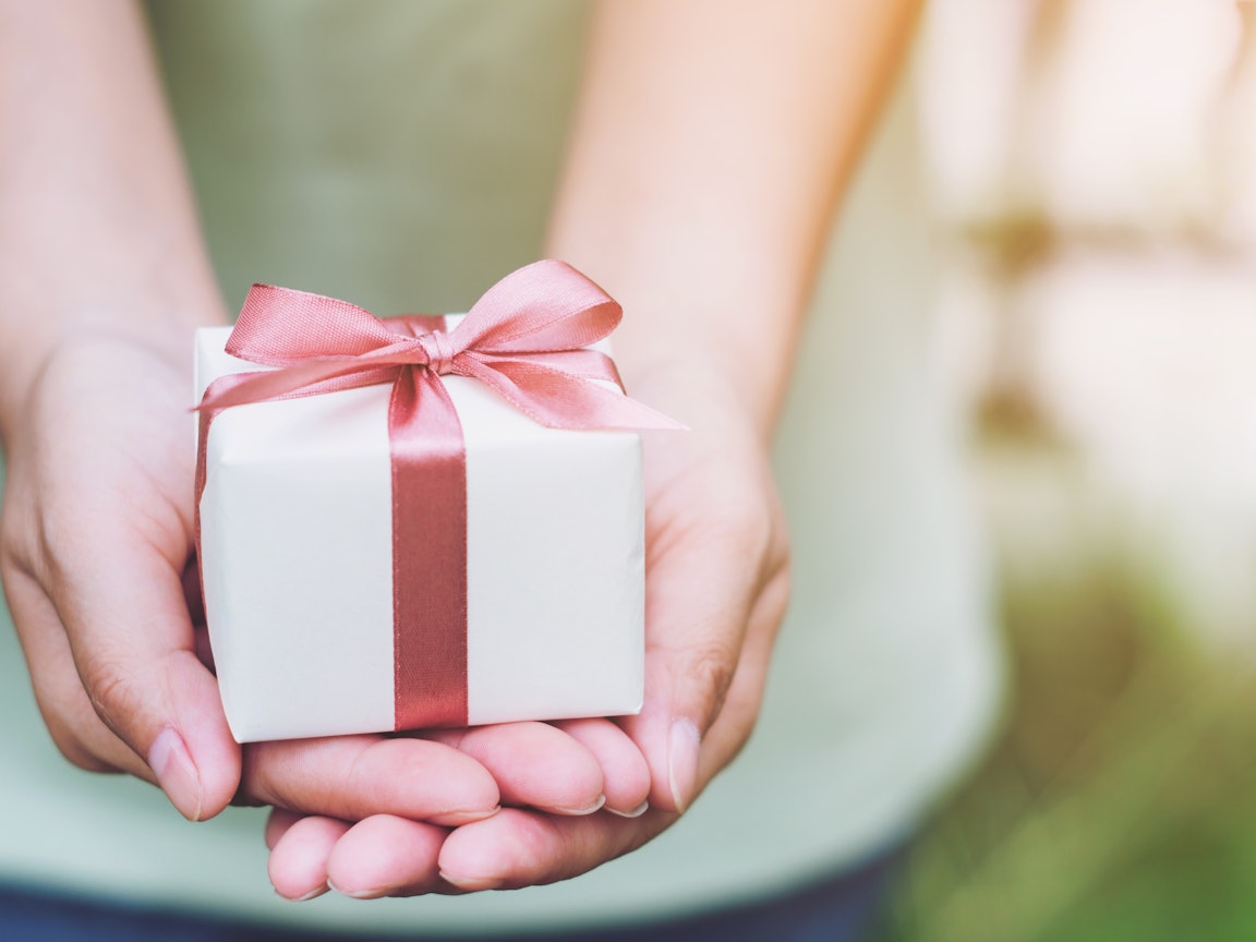 Frau hält ein Präsent in den Händen Frau hält ein Präsent in den Händen