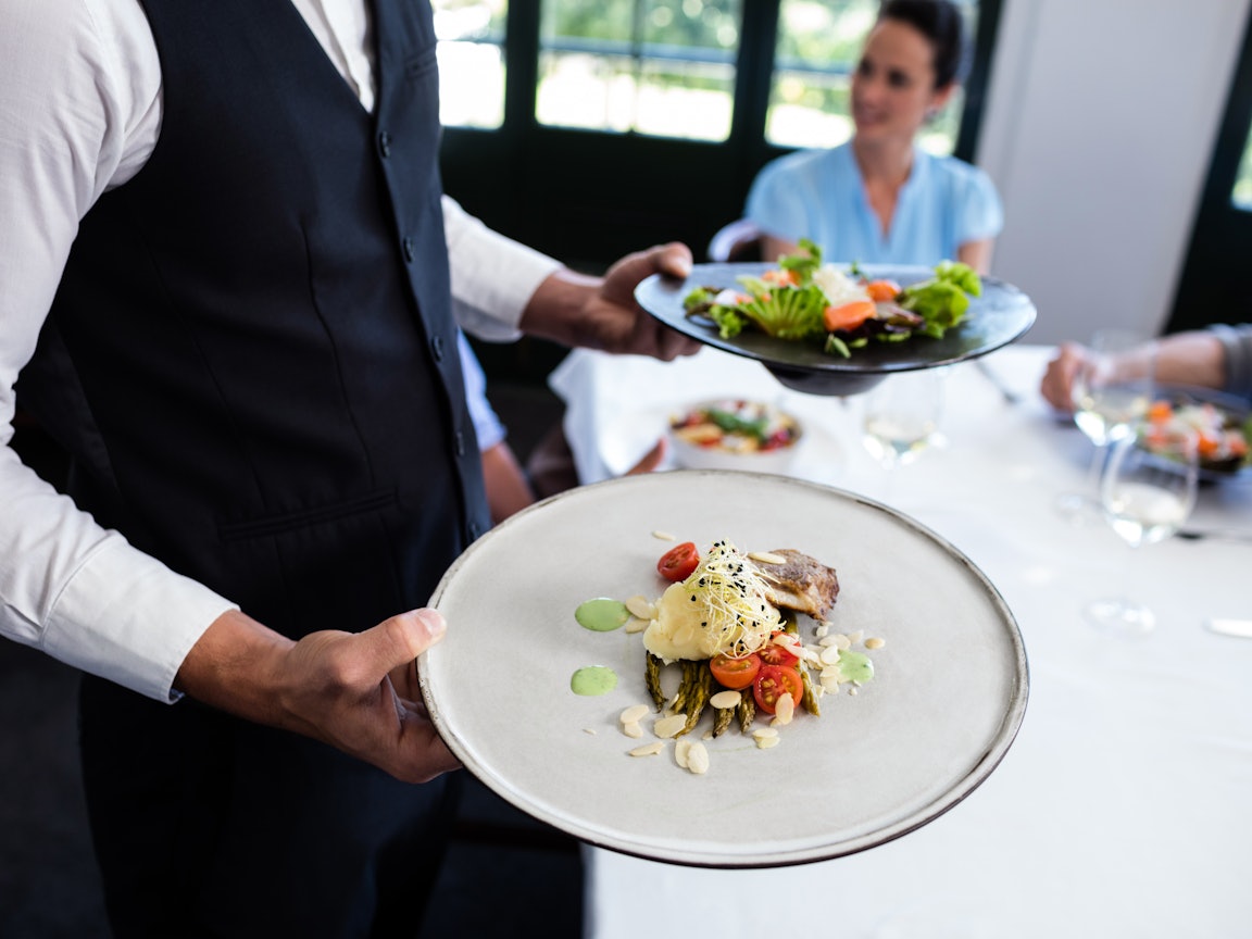 Kellner serviert hochwertiges Essen  Kellner serviert hochwertiges Essen
