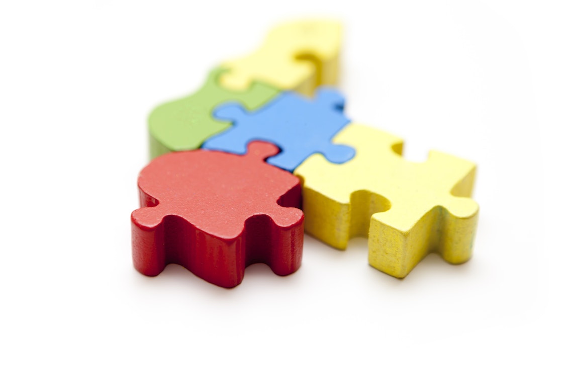 Bunte Puzzelteile aus Holz passen zusammen Bunte Puzzelteile aus Holz passen zusammen