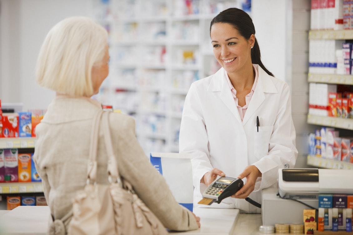 Kundin bezahlt Medikamente in der Apotheke