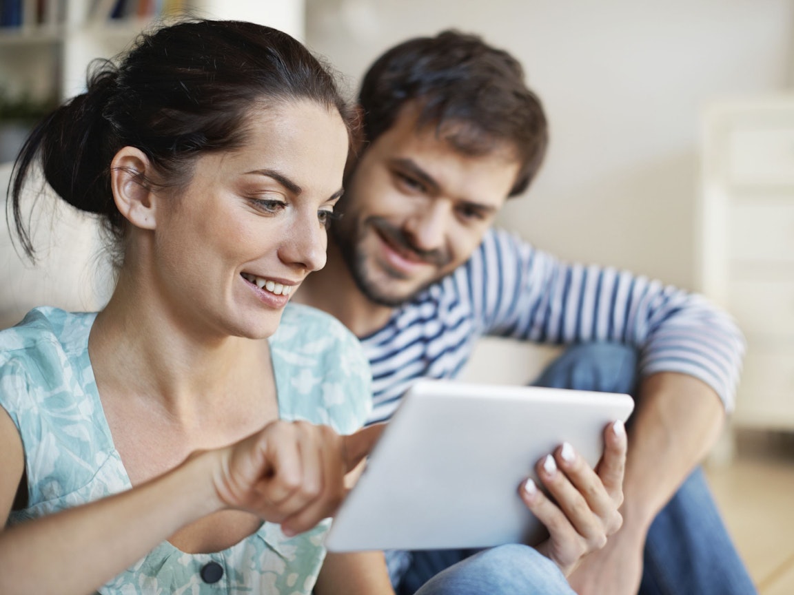 Junges Paar schaut in ein Tablet Junges Paar schaut in ein Tablet