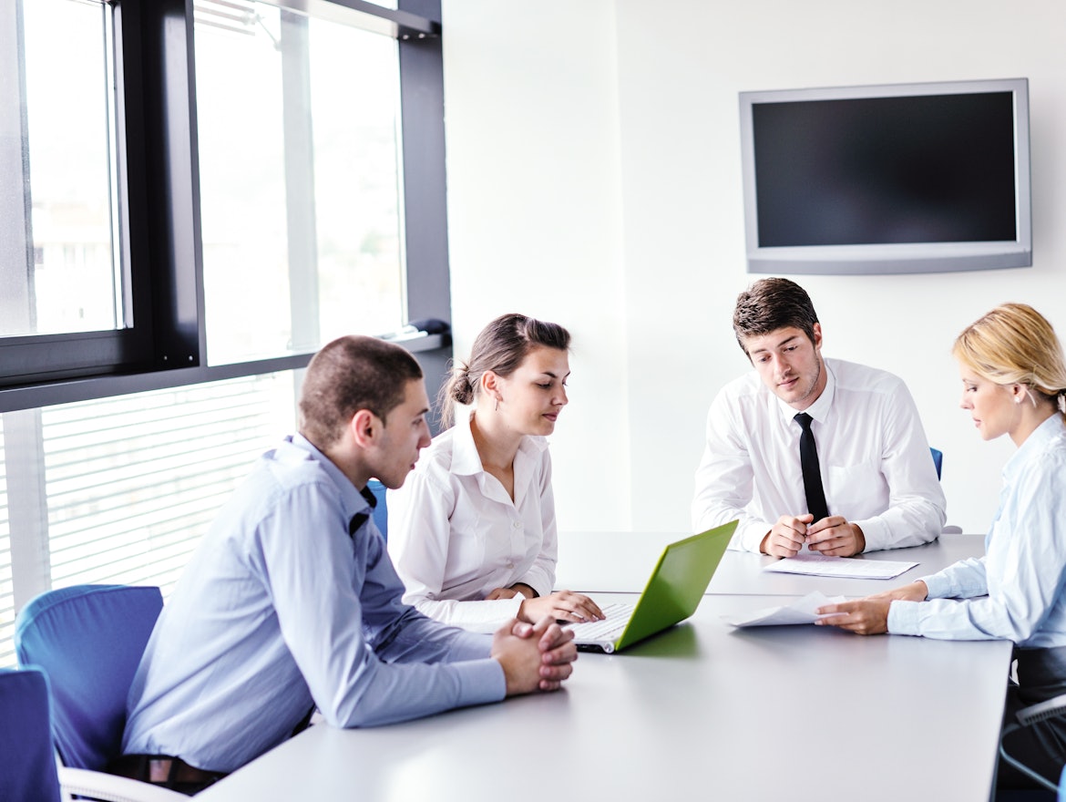 Gruppe junger Mitarbeiter sitzen in einer Besprechung
