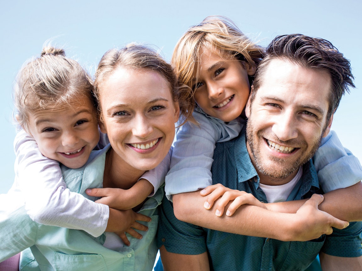 Familie mit zwei Kindern lachen in die Kamera Familie mit zwei Kindern lachen in die Kamera