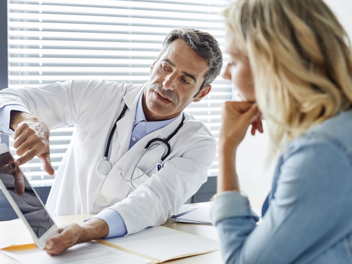 Der Arzt zeigt etwas auf dem Laptop Der Arzt zeigt etwas auf dem Laptop