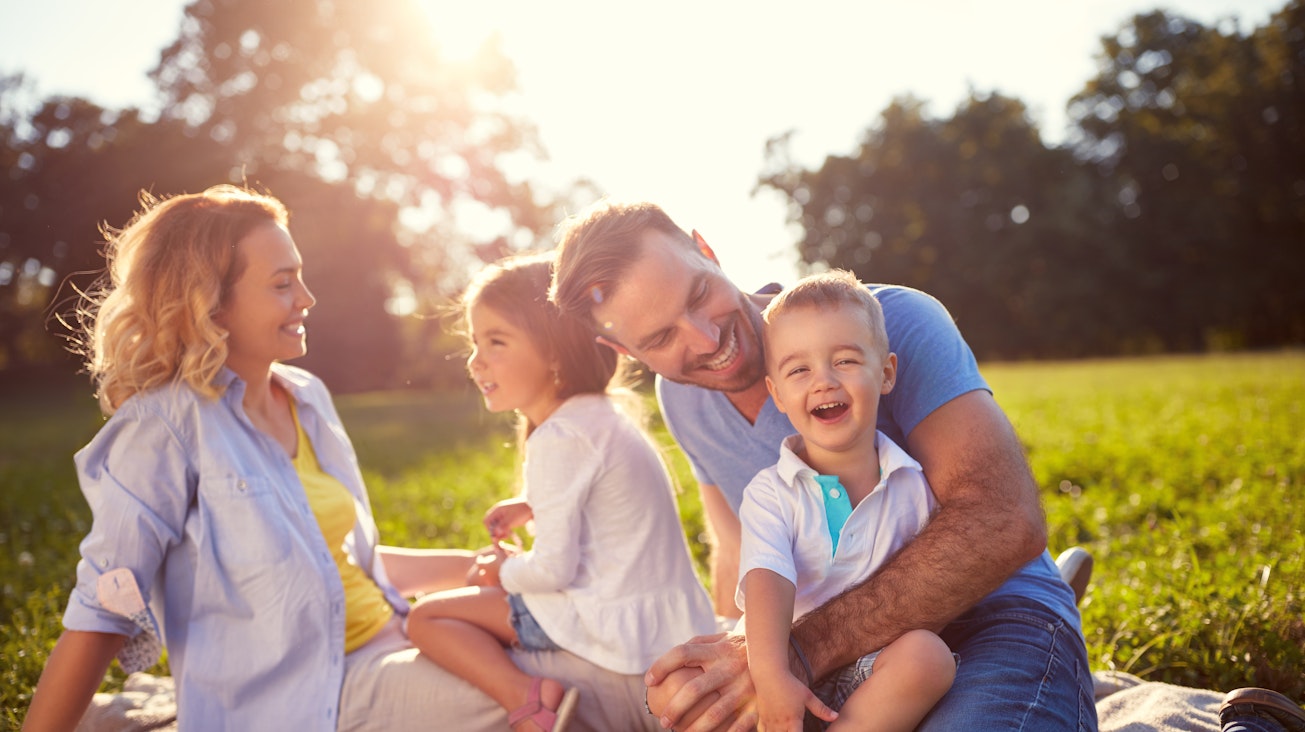 Eine Familie im Park Eine Familie sitzt auf eine Decke im Park
