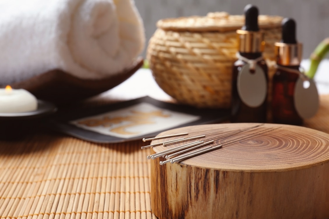 Traditionelle chinesische Behandlungsmethode Akupunkturnadeln liegen auf einem Holzstück