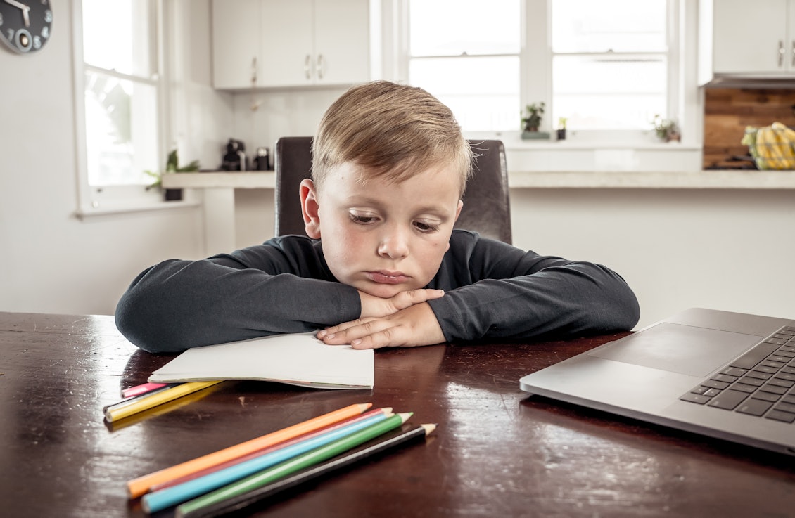 Psychische Erkrankungen bei Kinder und Jugendlichen nehmen zu Junge sitzt traurig beim Homeschooling