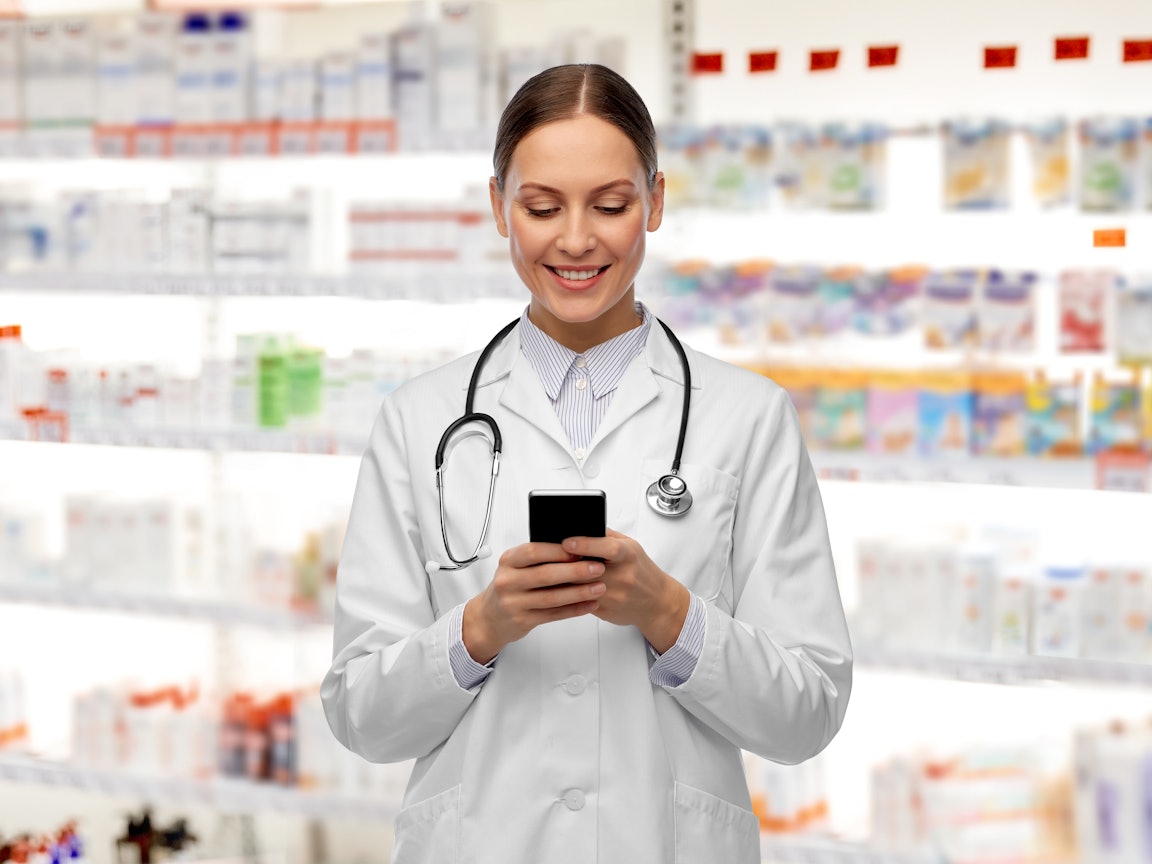 eRezepte können per Handy in der Apotheke eingereicht werden Eine Apothekerin schaut auf ihr Handy