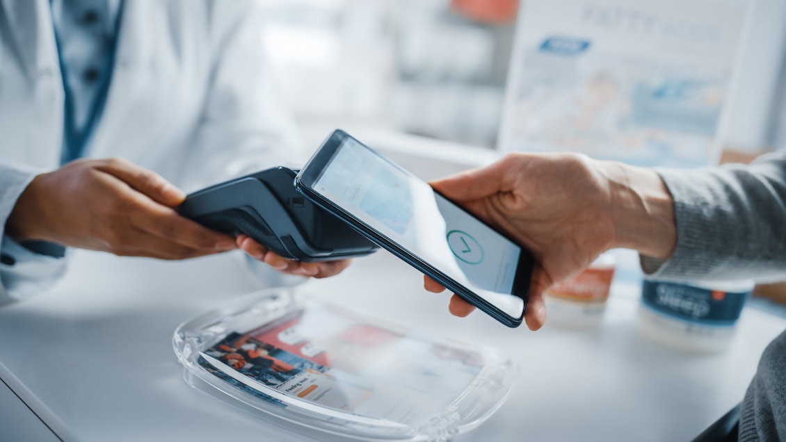 Mit der richtigen eGK, dem PIN und einem NFC-fähigen Smartphone, stehen alle Optionen der App zur Verfügung Ein Handy mit NFC wird in der Apotheke genutzt