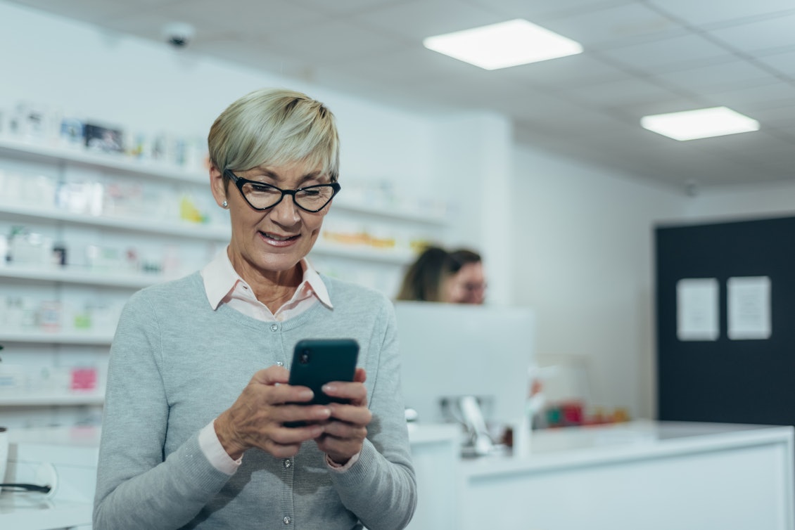 Eigene Rezepte immer griffbereit auf dem Smartphone Eine ältere Frau checkt die Rezepte auf dem Handy