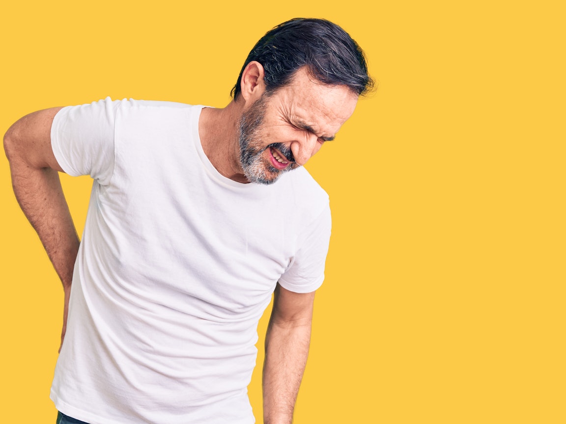 Rückenschmerzen betreffen viele Menschen in Deutschland Ein Mann verzerrt das Gesicht vor Rückenschmerzen