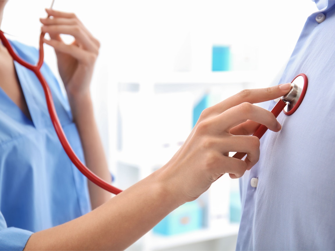 Ärztin untersucht Patientin Ärztin hört das Herz eines Patienten ab