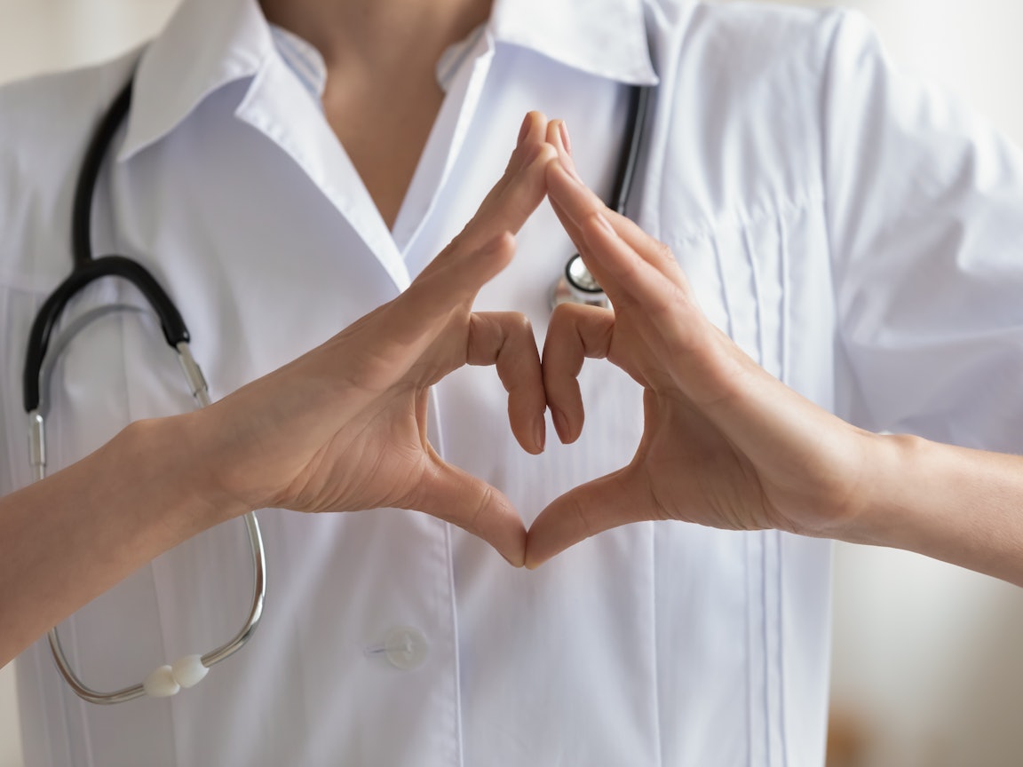 Der Dolmetscher wird für verschiedene medizinische Situationen bereitgestellt Eine Ärztin formt mit ihrer Hand ein Herz