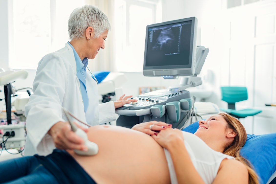 Eine schwangere Frau ist beim Frauenarzt und bekommt einen Ultraschall