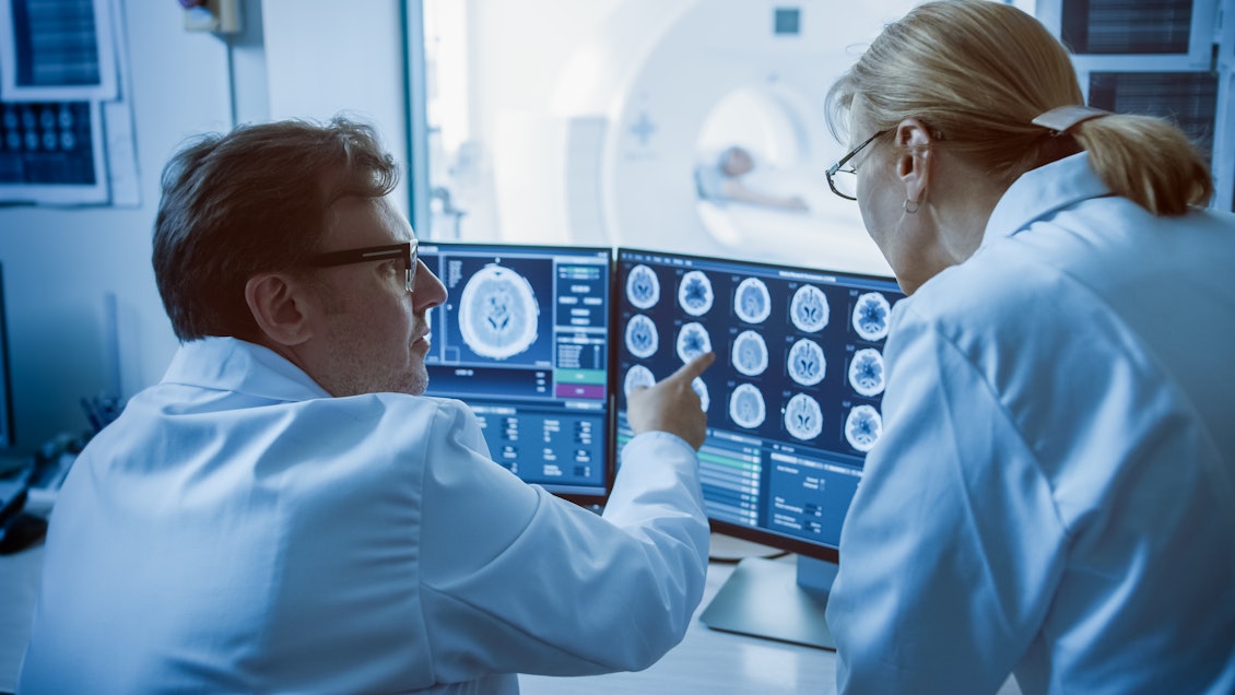 Arzt und Ärztin analysieren digitale Aufnahmen Digitale Aufnahmen werden von einem Arzt und einer Ärztin besprochen