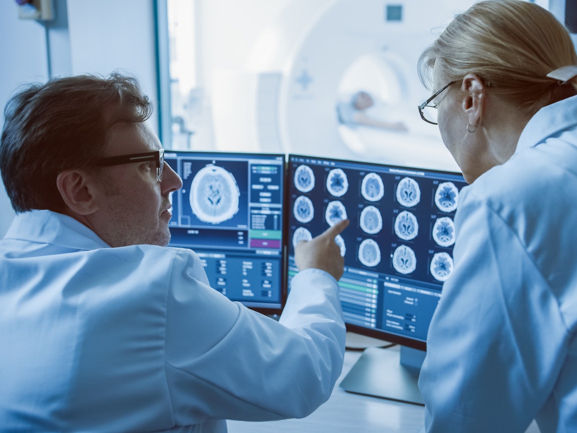 Arzt und Ärztin analysieren digitale Aufnahmen Digitale Aufnahmen werden von einem Arzt und einer Ärztin besprochen