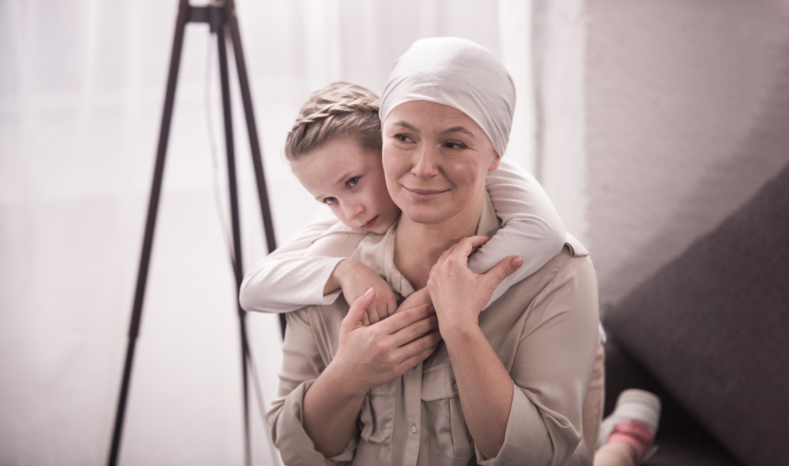 Kind umarmt Mutter von hinten Die Mutter wird von ihrer Tochter von hinten umarmt