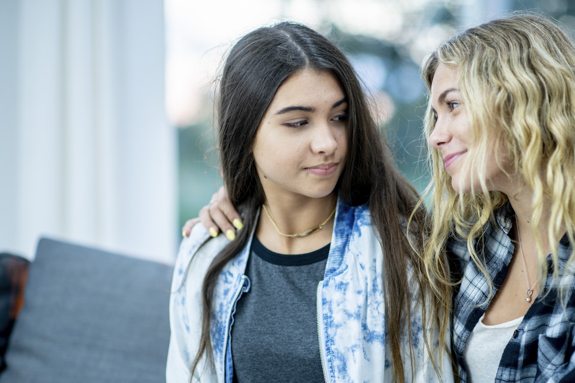 Jugendliches Mädchen lächtelt Freundin an Jugendliches Mädchen lächtelt Freundin an
