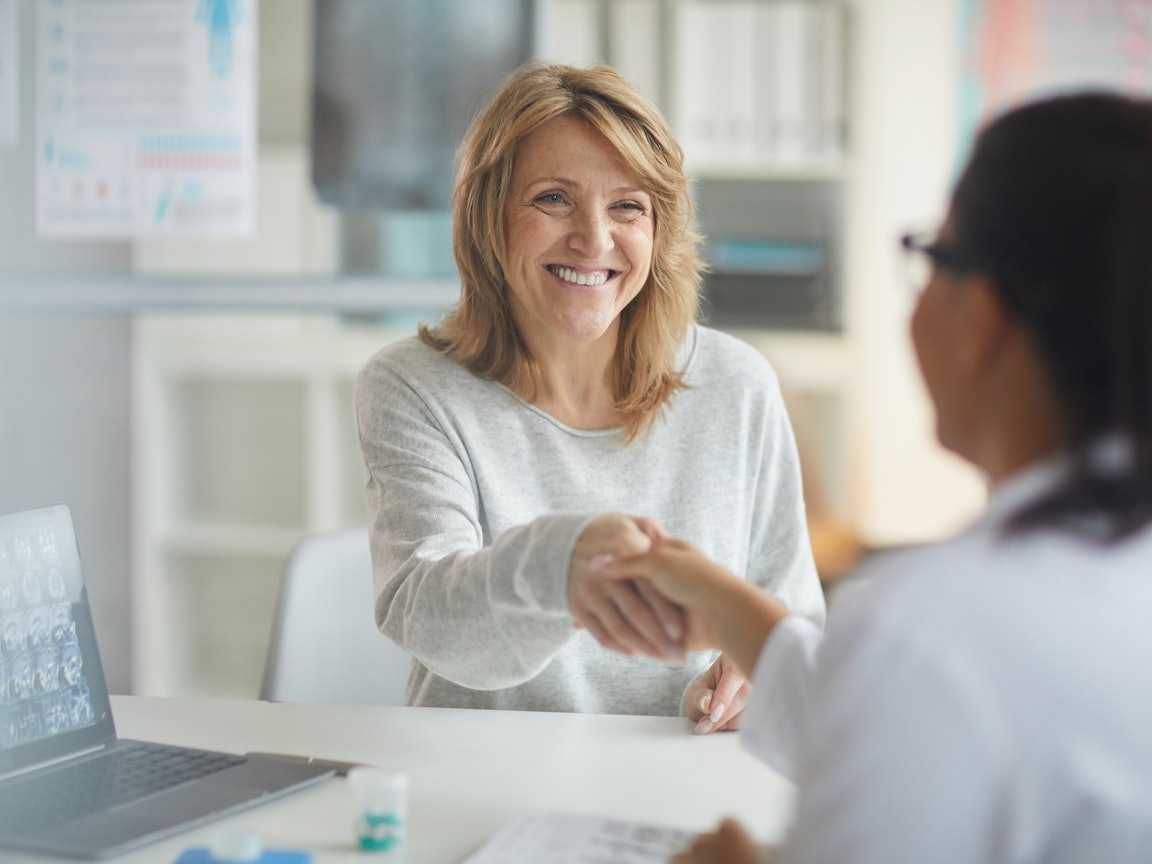 Frau begrüßt Ärztin Frau begrüßt Ärztin im Behandlungszimmer