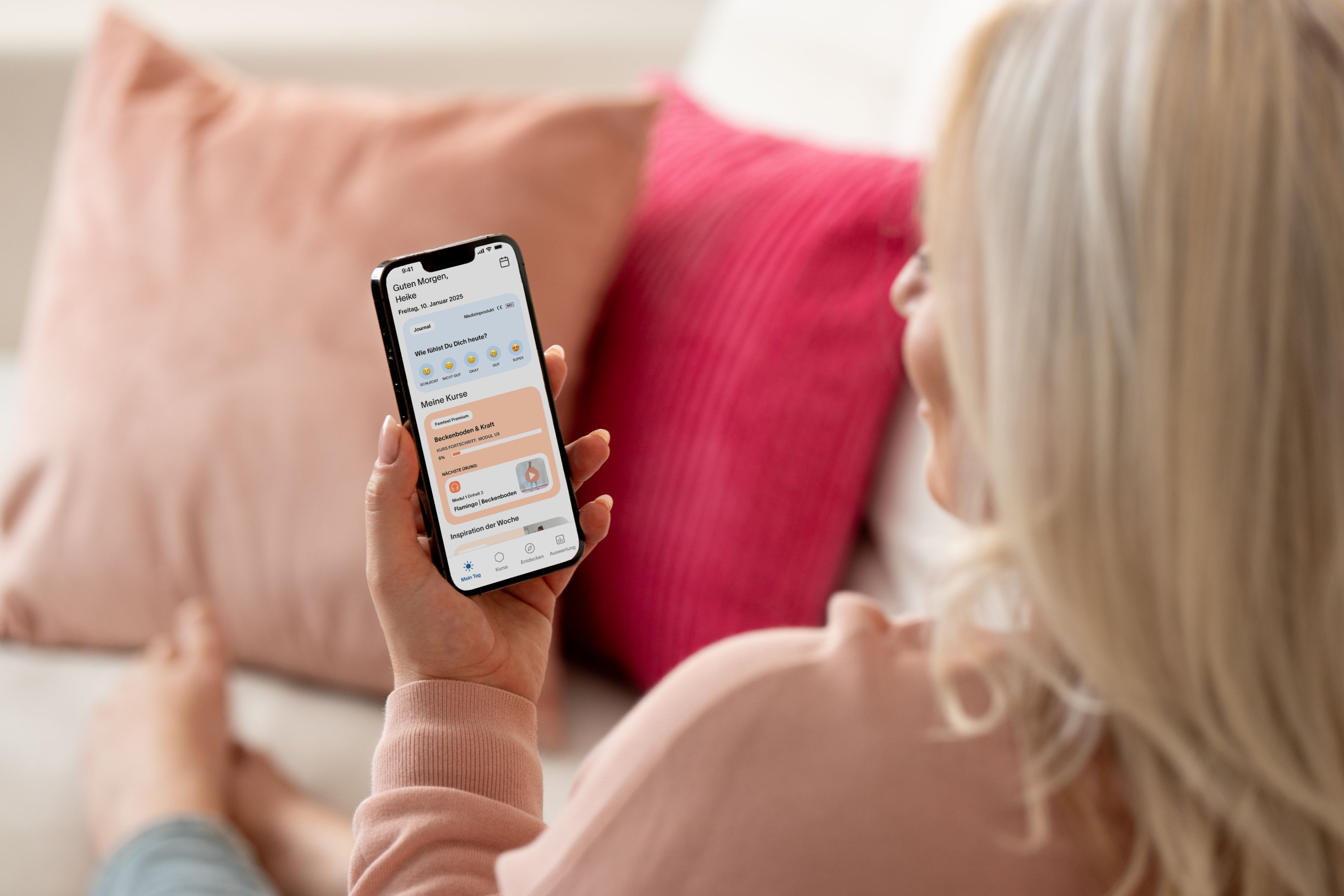 Frau sitzt auf der Couch und nutzt femfeel App