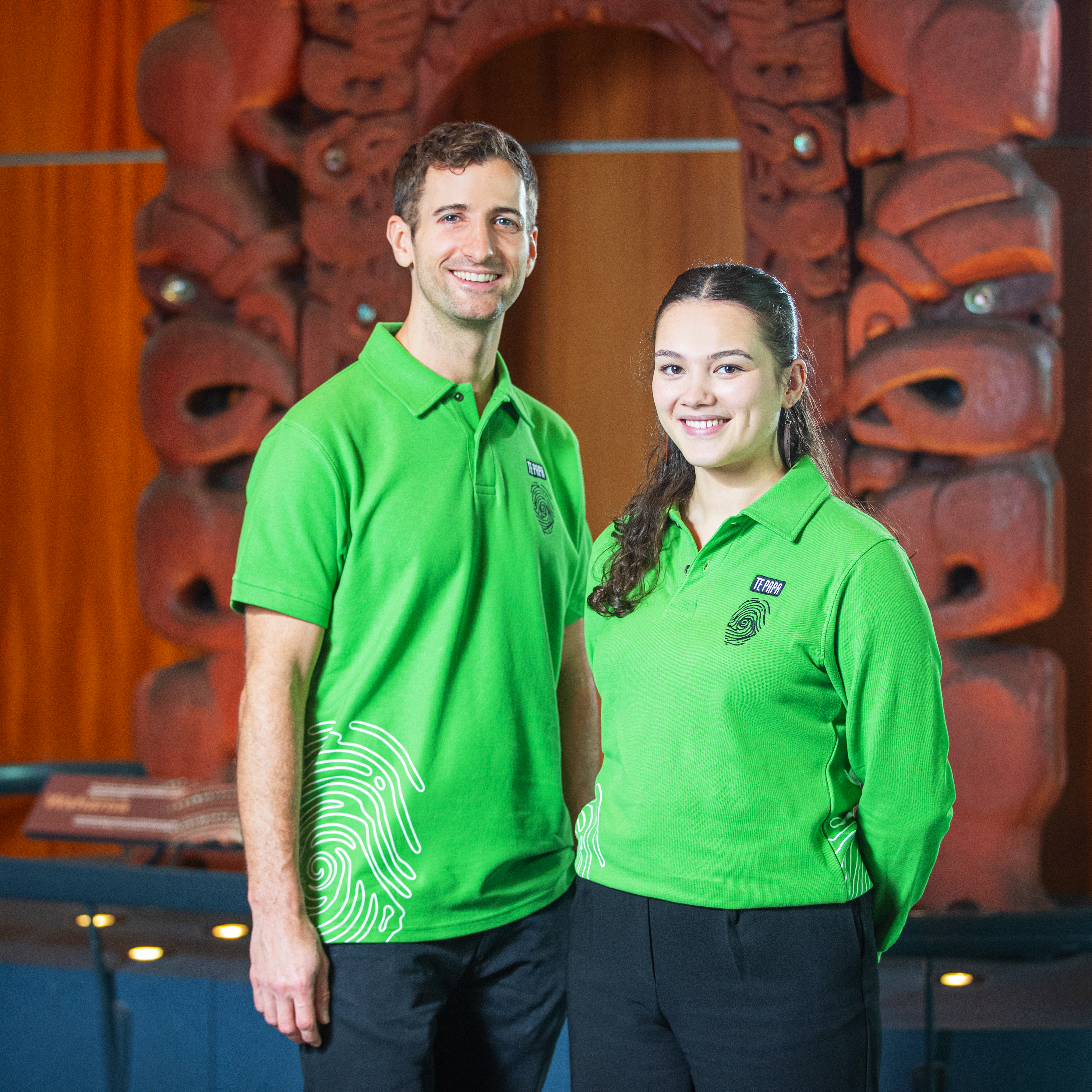 Te Papa Hosts stand in front of the waharoa (gateway).
