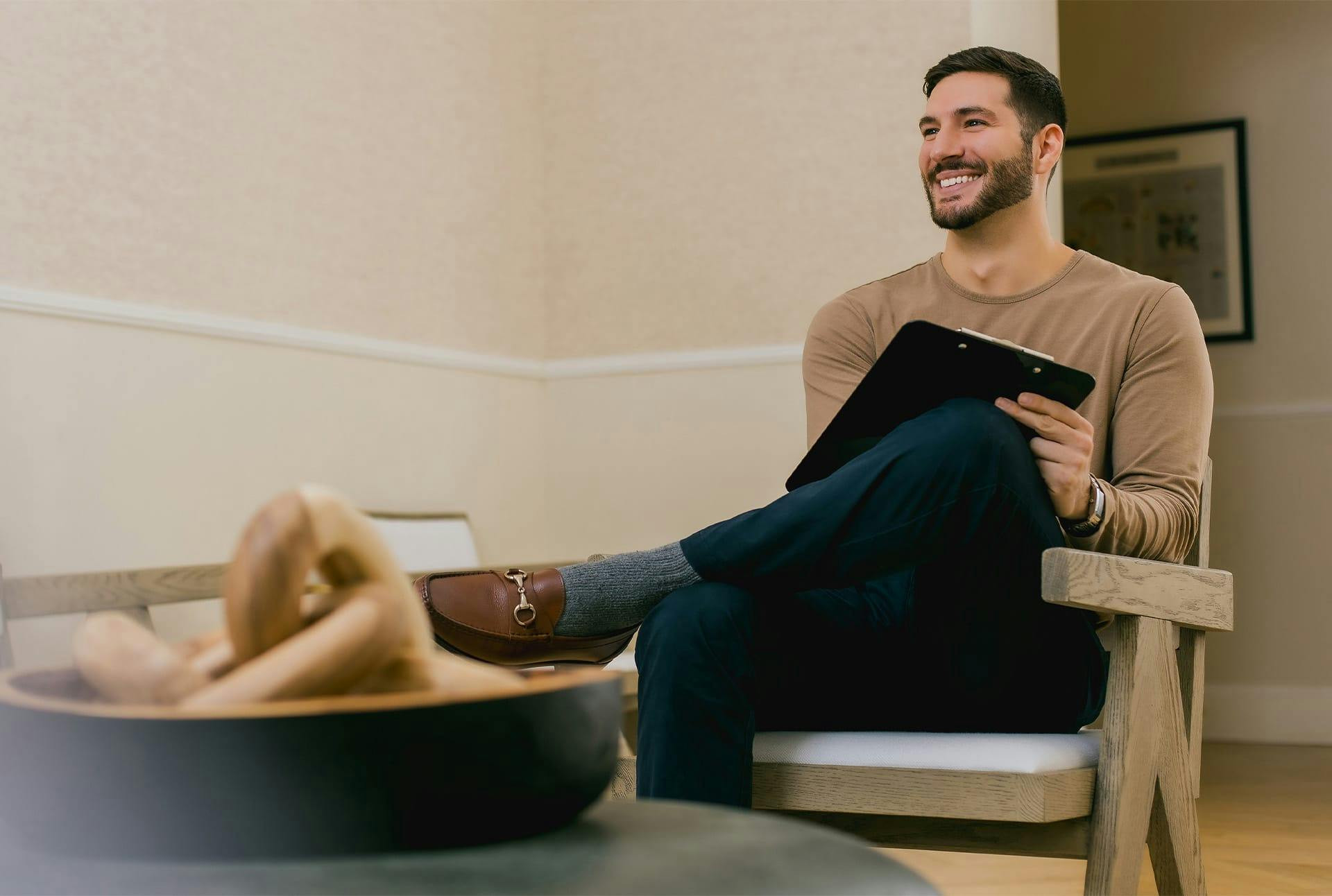 man sitting in waiting room smiling