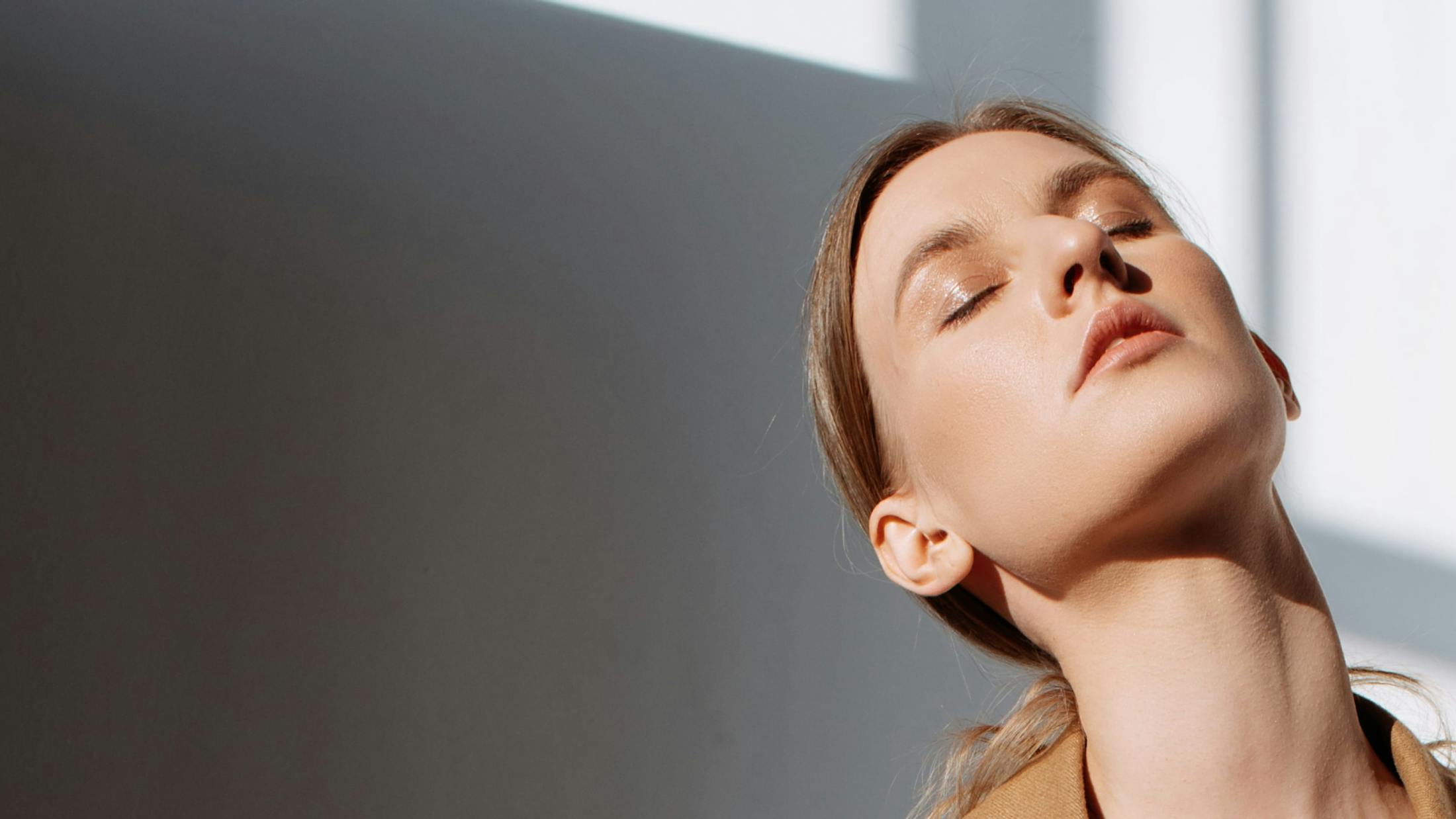 woman tilting her head upwards with her eyes closed