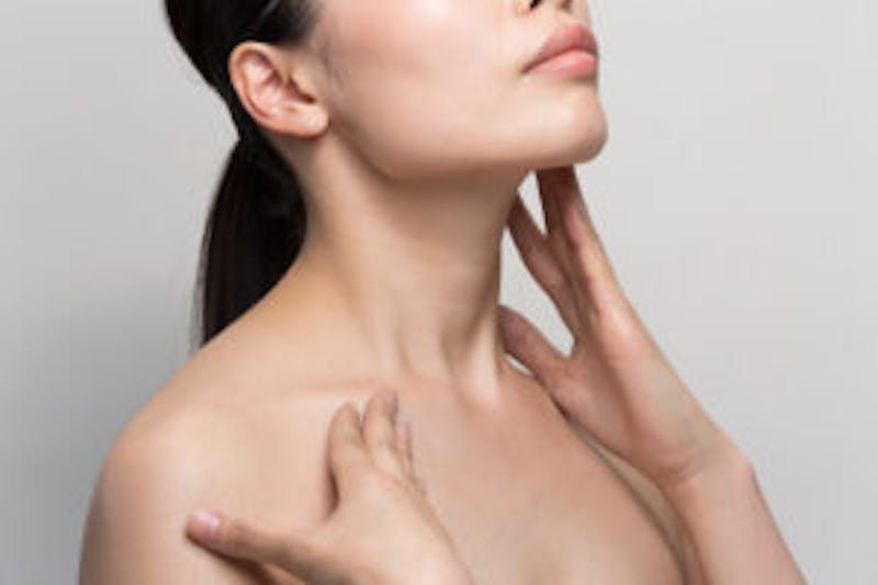 woman touching her neck