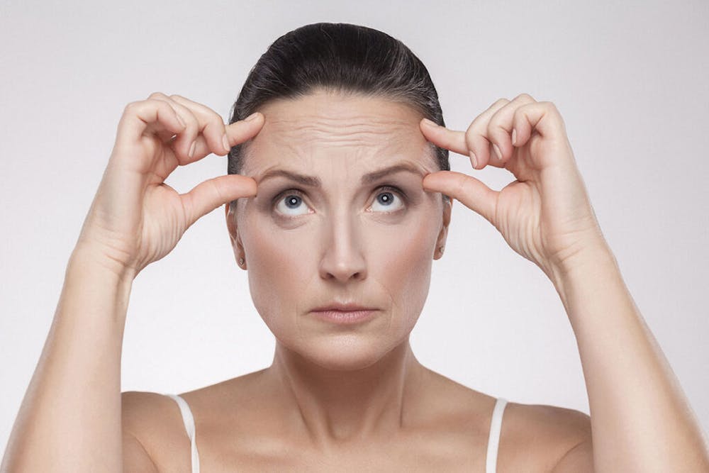 A soon-to-be brow lift patient with visible signs of aging in the eyebrow area.