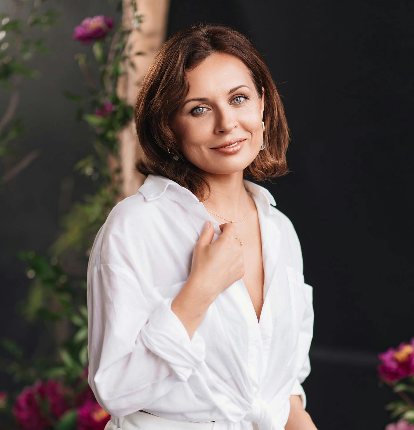 woman smiling, holding her shirt collar