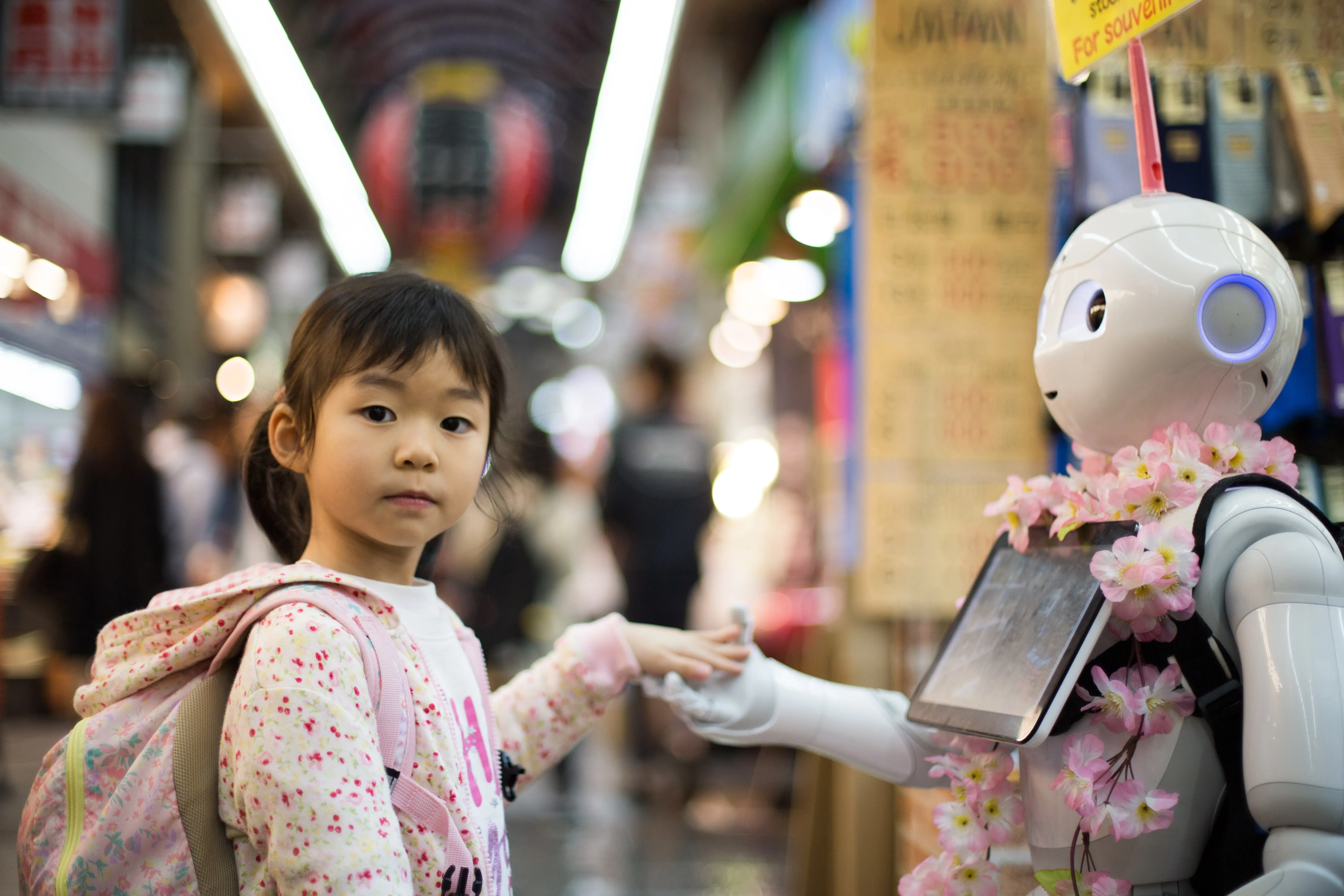 A photo of a girl shaking hands with a robot