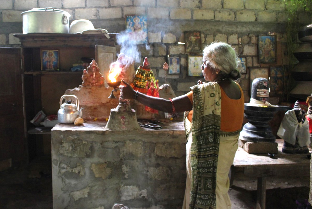 A woman lighting incense at a shrine