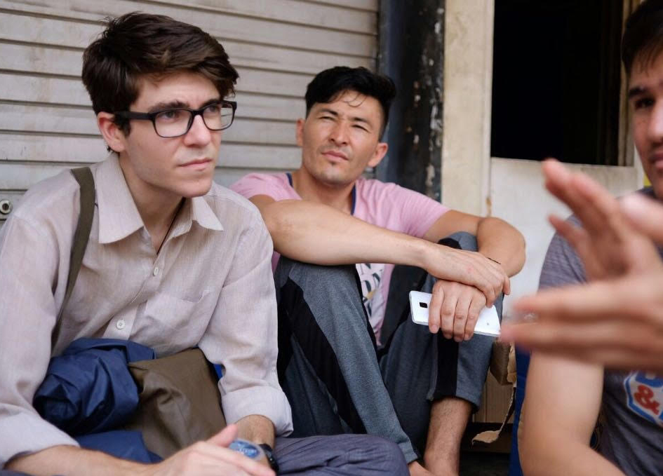 Jounrlaist interviewing a small group of people facing each other
