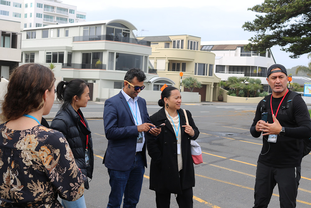 A man chatting to a small group standing in a carpark