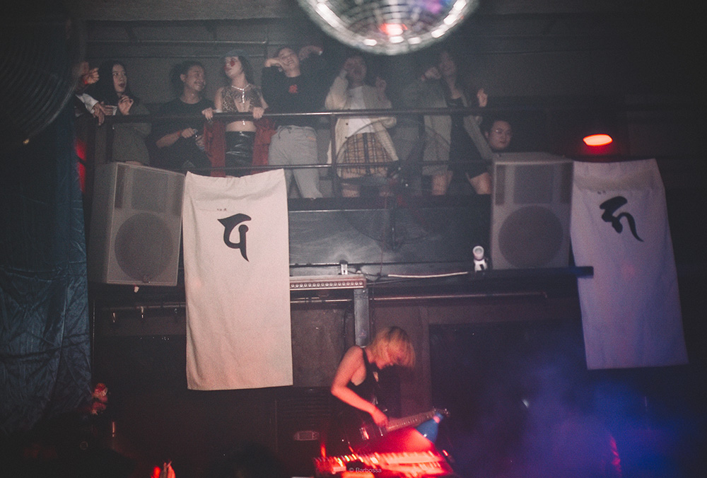 People watching a band playing in a dimly-lit room