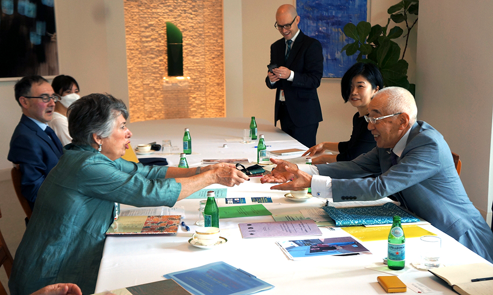 Dame Fran Wilde passing her card across a table to a japanese Track II participant