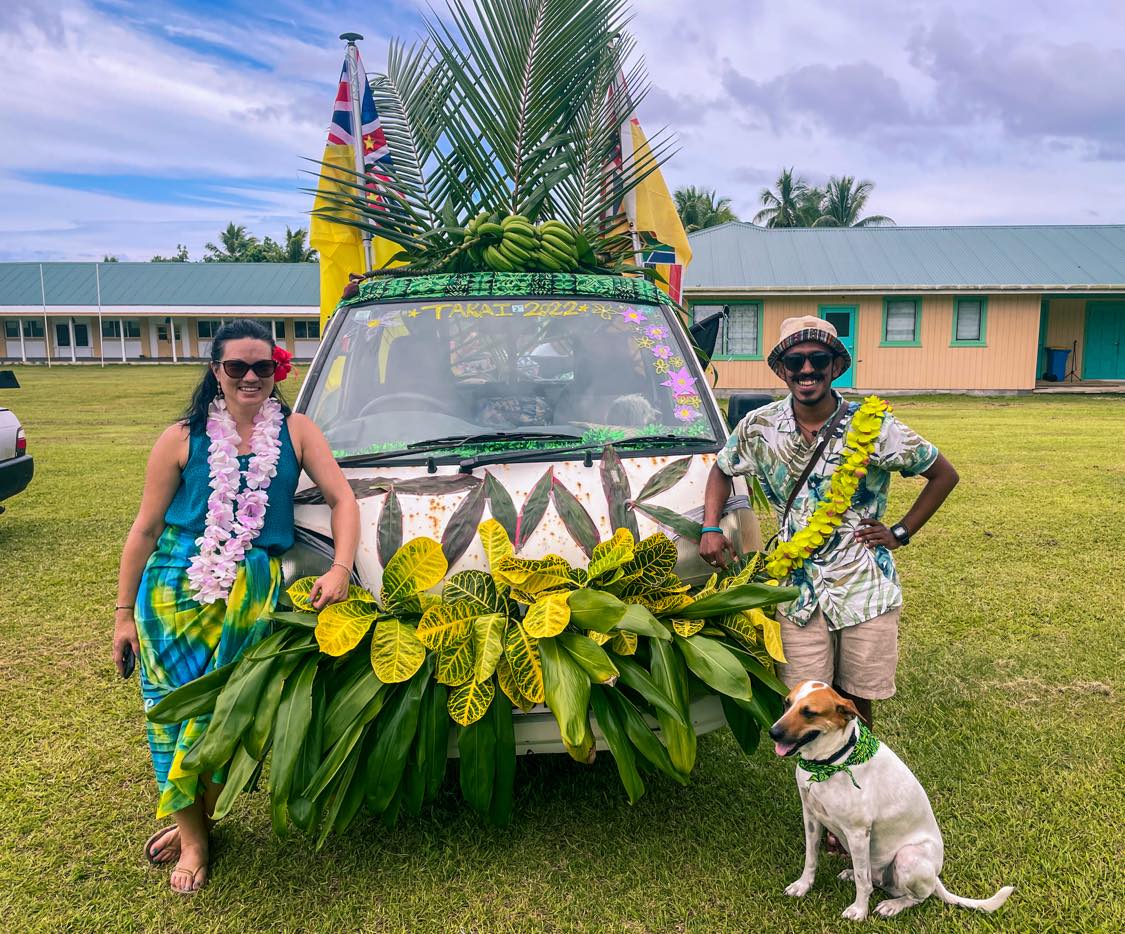 Ajay and Dana standing in front of a car adorned with leaves